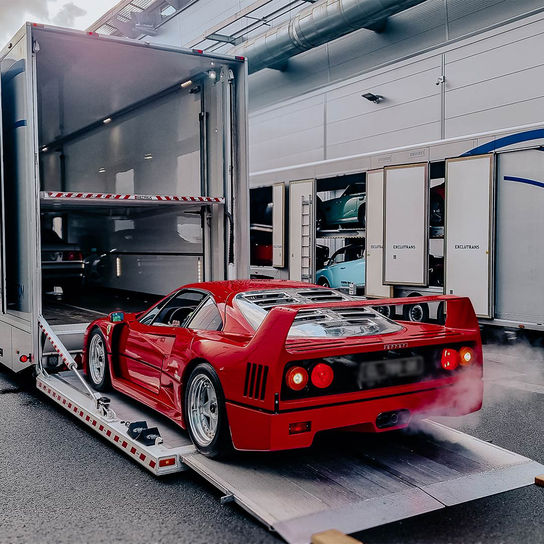 Exclutrans grote gesloten vrachtwagen voor internationaal transport tijdens het inladen van een luxe wagen.