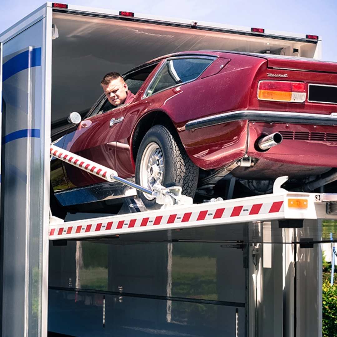 Exclutrans gesloten vrachtwagen tijdens het laden van exclusieve voertuigen.